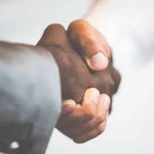 Two individuals shaking hands against a white background