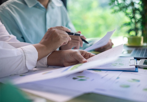 Real estate professionals reviewing papers with charts, illustrating DWI impact on careers in Middletown, NY.